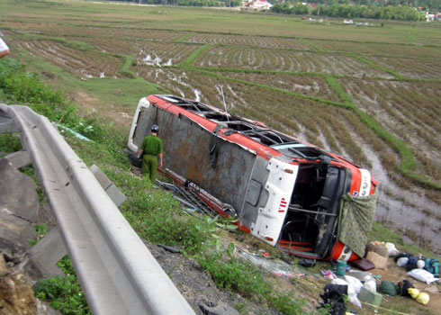 Xe khách lật nghiêng bên bờ ruộng.